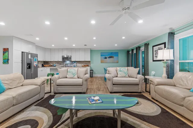 a living room with furniture and a view of kitchen