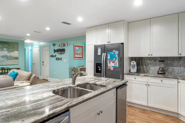 a kitchen with stainless steel appliances granite countertop a sink and a refrigerator