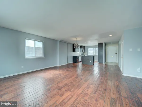 a view of empty room with kitchen and window