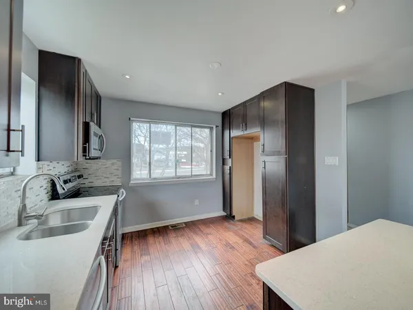 a kitchen with wooden floors and refrigerator