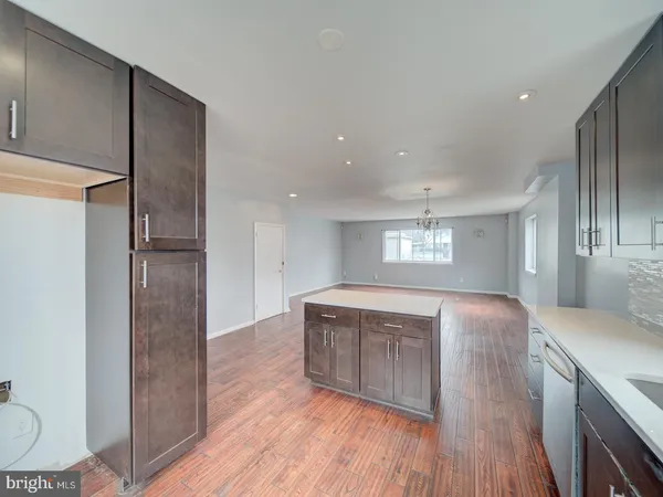 a kitchen with stainless steel appliances granite countertop a refrigerator a sink and wooden floors