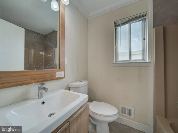 a bathroom with a sink mirror and toilet