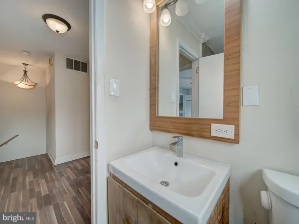 a bathroom with a sink and mirror with toilet