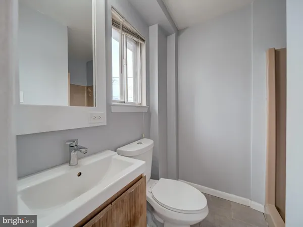 a bathroom with a sink a toilet and window