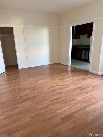 an empty room with wooden floor and window