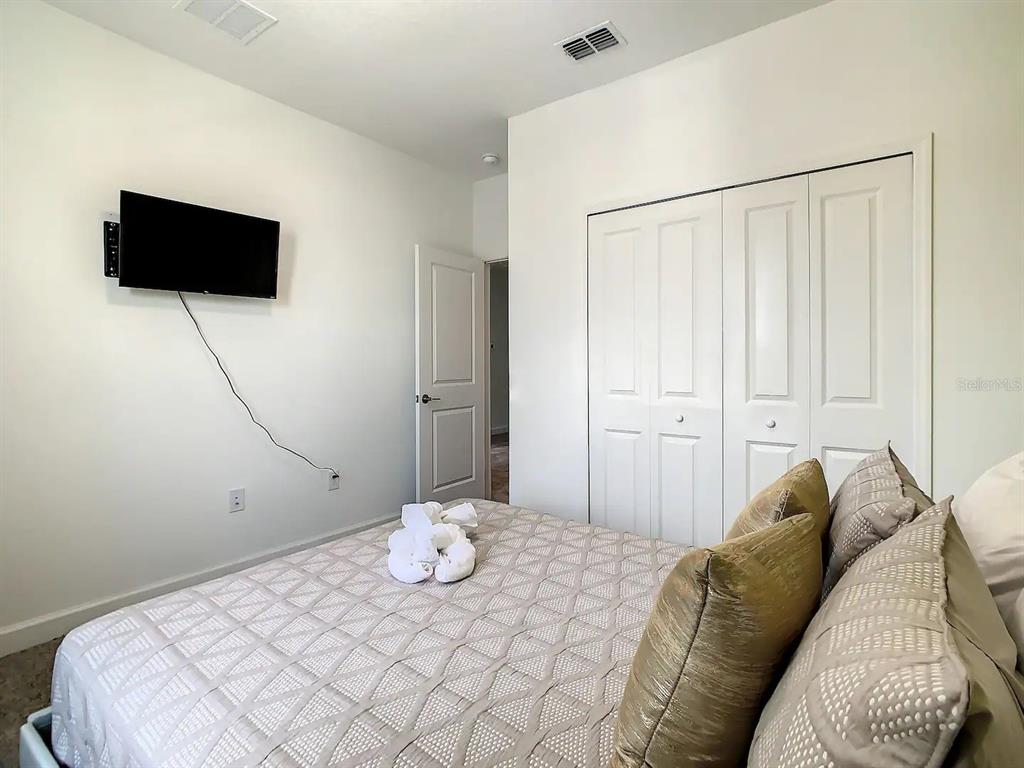 2908 Protagonist Street Kissimmee, FL 34746 - Photo 11 of 32 a bedroom with a bed and flat screen tv