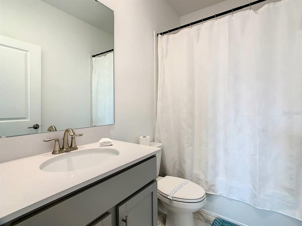 2908 Protagonist Street Kissimmee, FL 34746 - Photo 25 of 32 a bathroom with a sink a toilet and a mirror