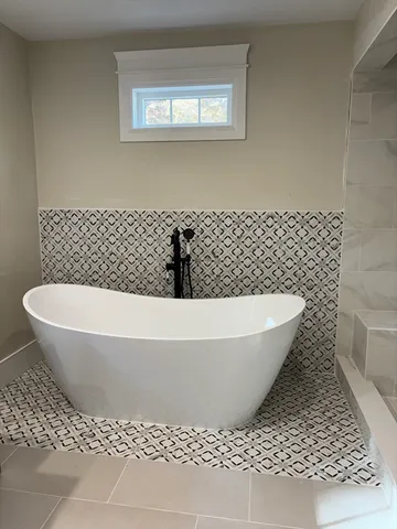 a white bath tub sitting next to a white wall