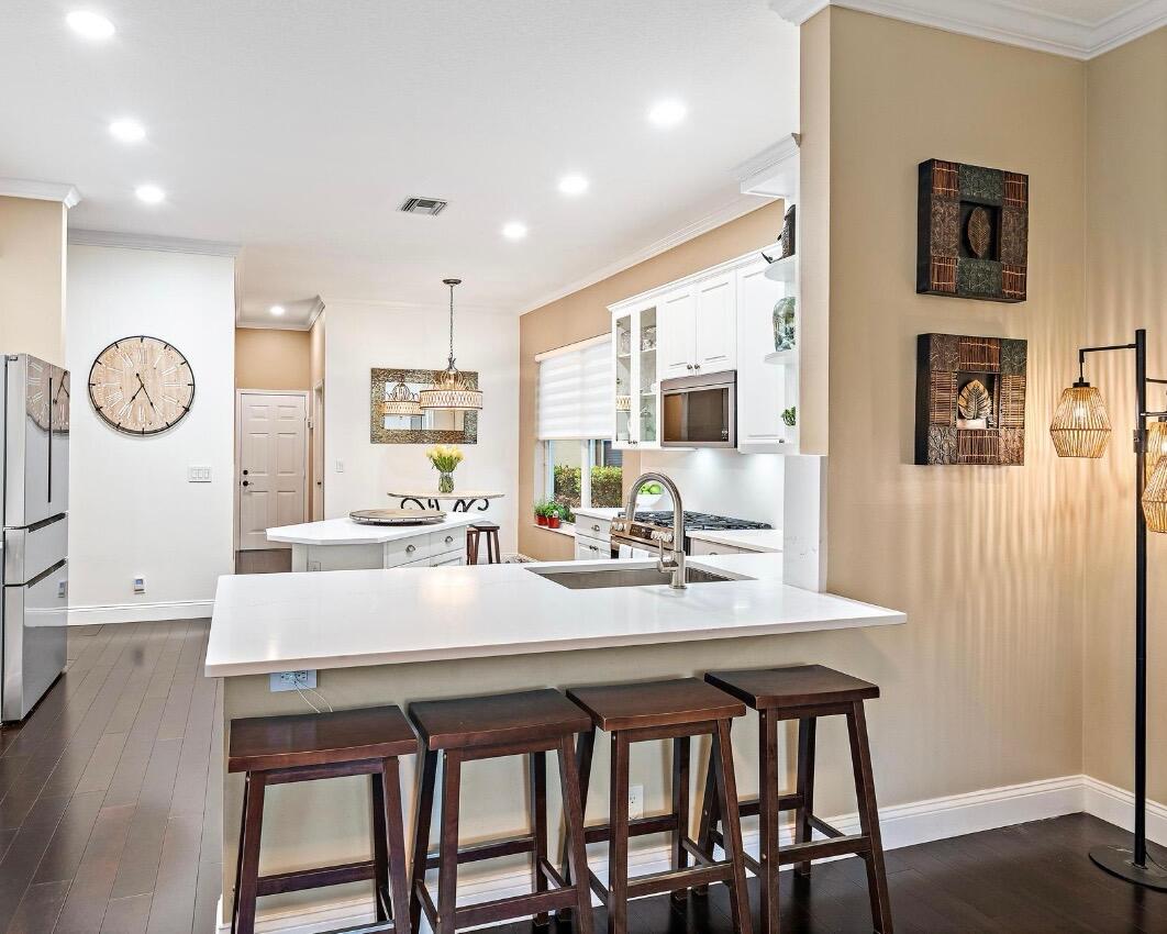 265 Swallowtail Lane Jupiter, FL 33458 - Photo 6 of 37 a kitchen with a table chairs stove and cabinets