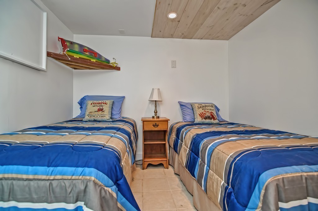 56 Marmion Way Rockport, MA 01966 - Photo 24 of 30 a bedroom with two beds and a painting on the wall