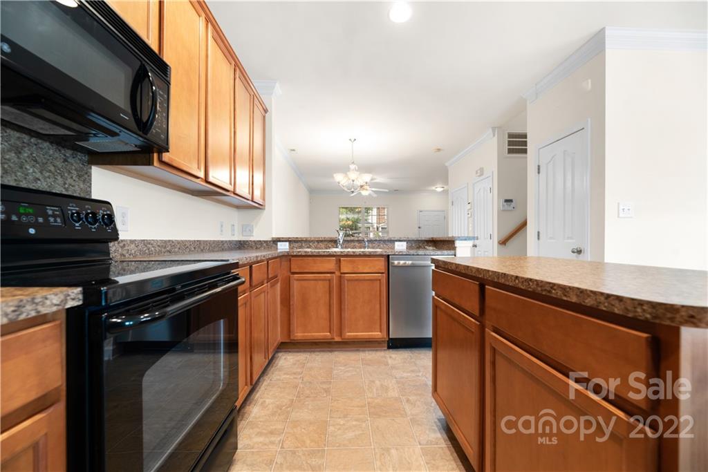 5133 Prosperity Church Road Charlotte, NC 28269 - Photo 11 of 37 a kitchen with stainless steel appliances granite countertop a stove top oven a sink and a microwave