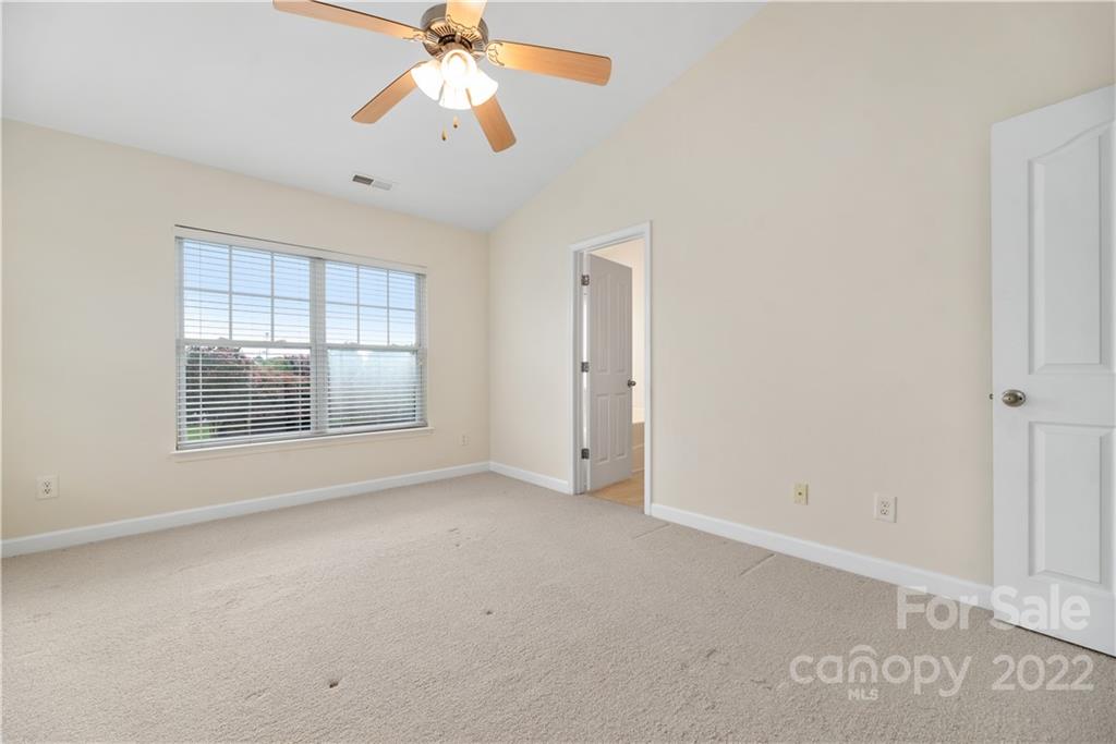 5133 Prosperity Church Road Charlotte, NC 28269 - Photo 18 of 37 an empty room with chandelier fan and windows