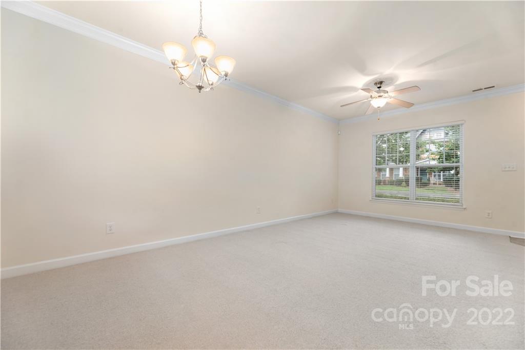 5133 Prosperity Church Road Charlotte, NC 28269 - Photo 9 of 37 an empty room with windows and chandelier fan