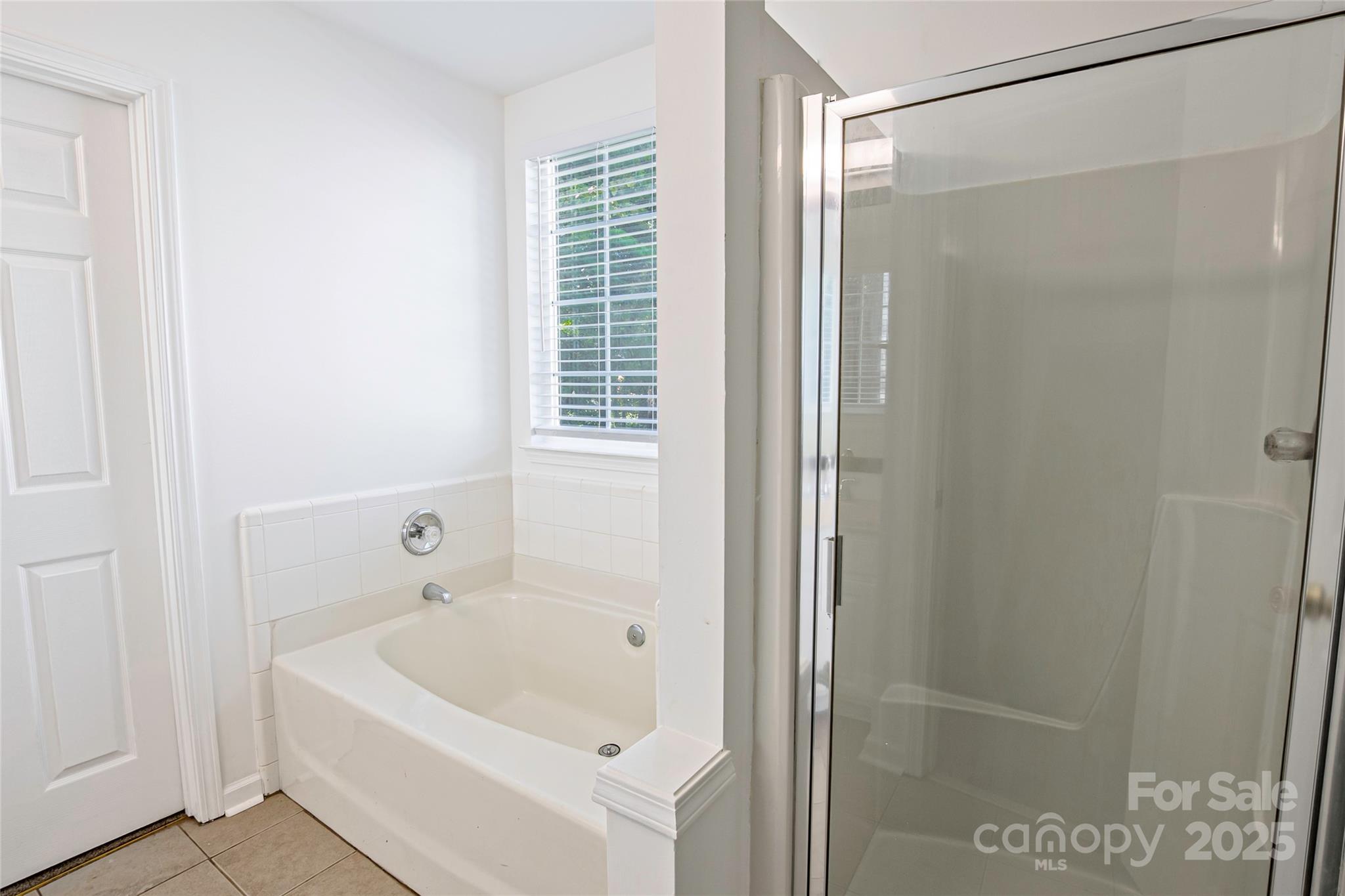 14034 Dingess Road, Unit 101 Charlotte, NC 28273 - Photo 19 of 24 a bathroom with a bathtub and a shower