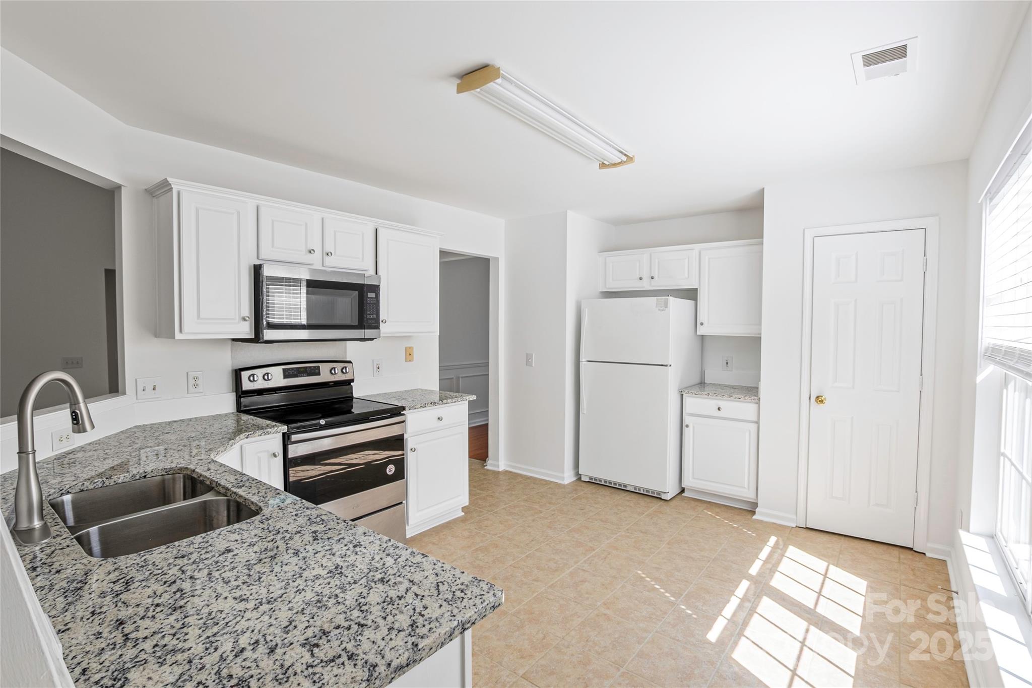 14034 Dingess Road, Unit 101 Charlotte, NC 28273 - Photo 2 of 24 a kitchen with stainless steel appliances kitchen island granite countertop a refrigerator and a sink