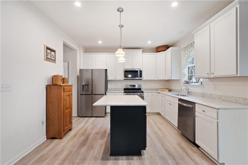 205 Wyncrest Drive Butler, PA 16001 - Photo 5 of 23 a kitchen with stainless steel appliances granite countertop a refrigerator a sink dishwasher a stove and white countertops with wooden floor