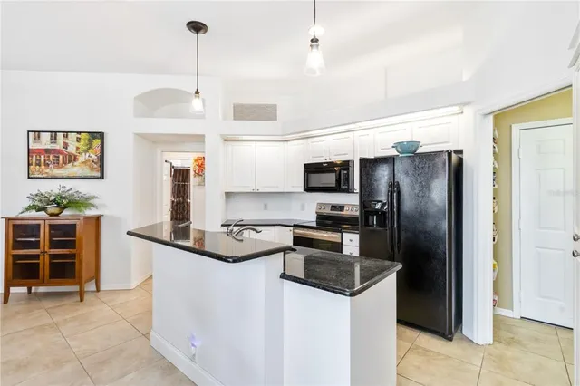 a view of a dining room and livingroom with furniture wooden floor a chandelier
