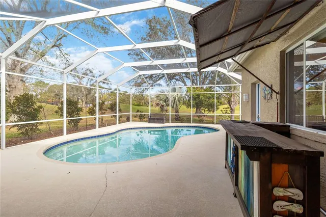 a aerial view of a house next to a yard with big trees