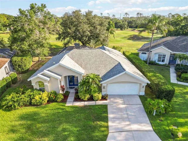 an aerial view of a house with a yard and lake view
