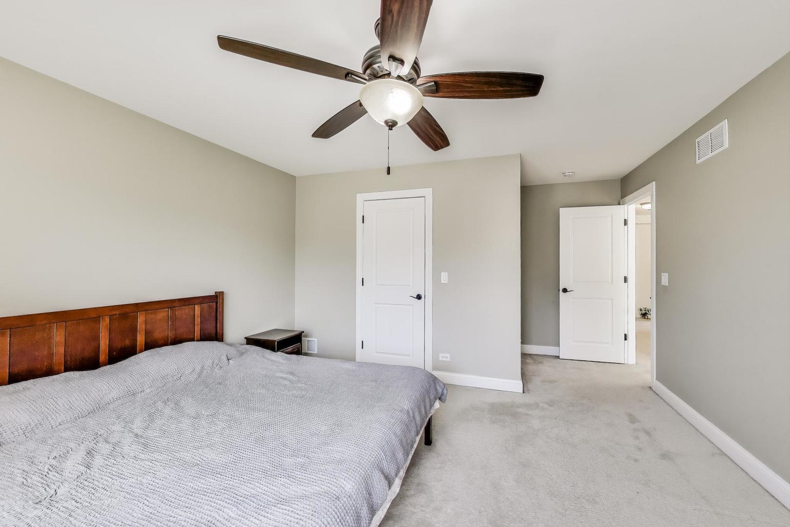 1064 Ridgeview Drive Inverness, IL 60010 - Photo 29 of 48 a bedroom with a large bed and a chandelier