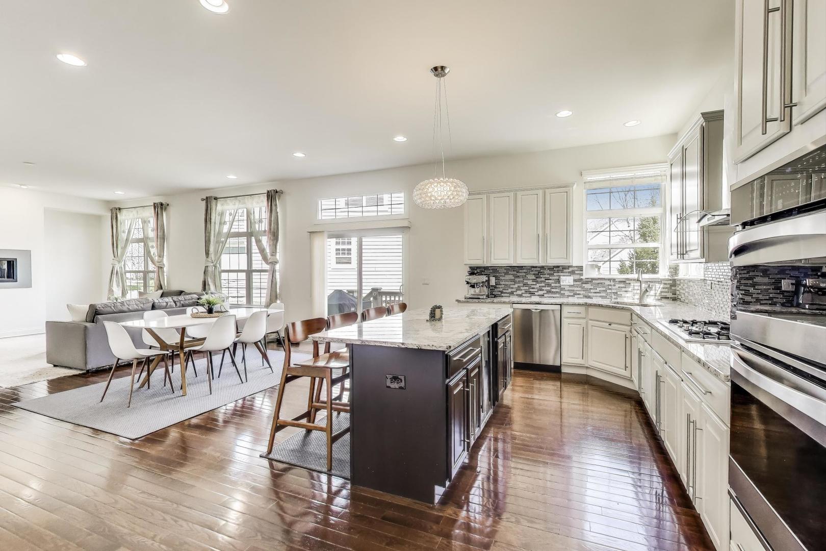 1064 Ridgeview Drive Inverness, IL 60010 - Photo 10 of 48 a kitchen with stainless steel appliances granite countertop a stove top oven a sink dishwasher a dining table and chairs with wooden floor