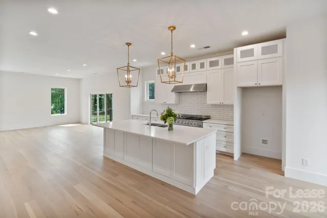 a large white kitchen with lots of counter space and a sink