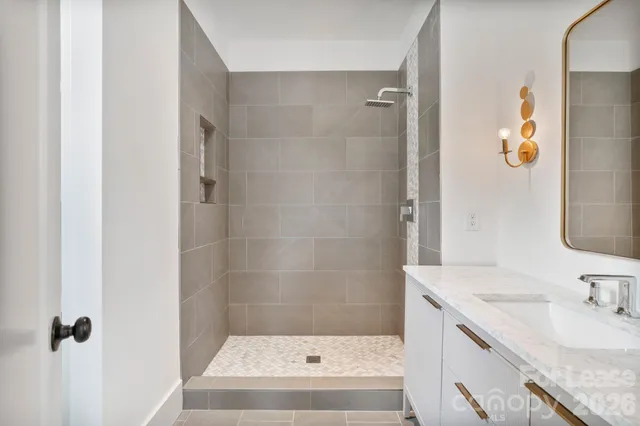 a bathroom with a granite countertop sink a mirror a bathtub and shower