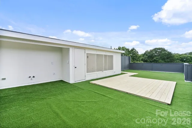 a view of a backyard with grass and a garage