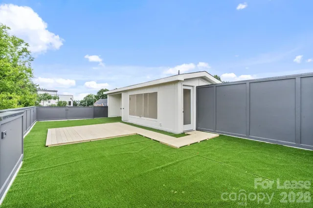 a view of an house with backyard space and balcony