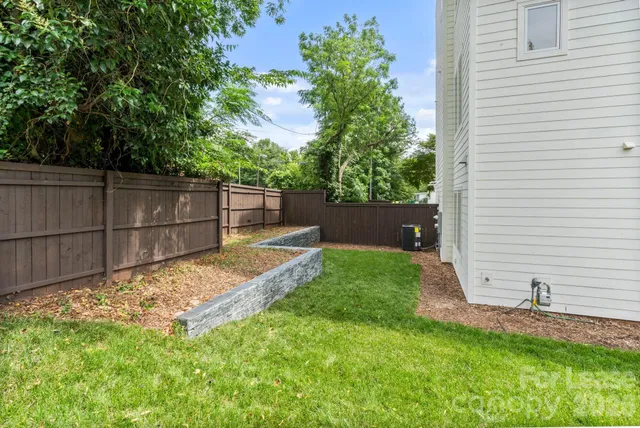 a view of backyard with wooden fence