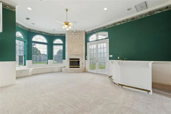 a view of an empty room with a fireplace and a window