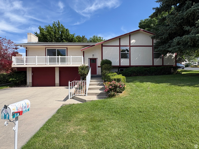 595 Meadowlark Road Orem, UT 84097 - Photo 87 of 87 Split-level residence featuring a two-car garage with red doors and a front-facing balcony with white railing