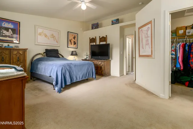 a spacious bedroom with a bed and a flat screen tv