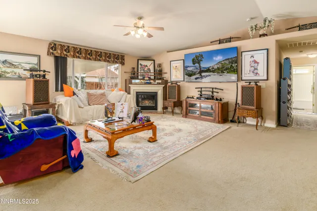 a living room with furniture a flat screen tv and kitchen view