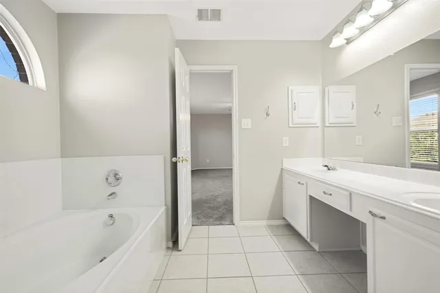 a bathroom with a bathtub sink and mirror