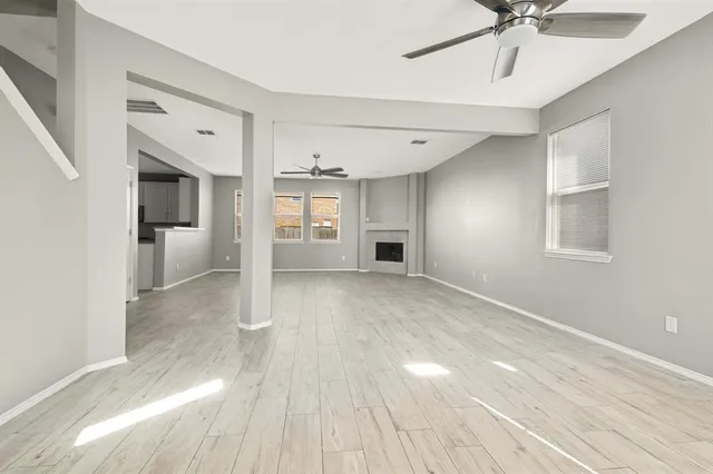 a view of a livingroom with wooden floor and a ceiling fan