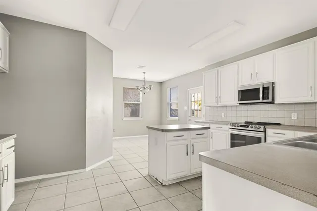 a kitchen with white cabinets stainless steel appliances and sink