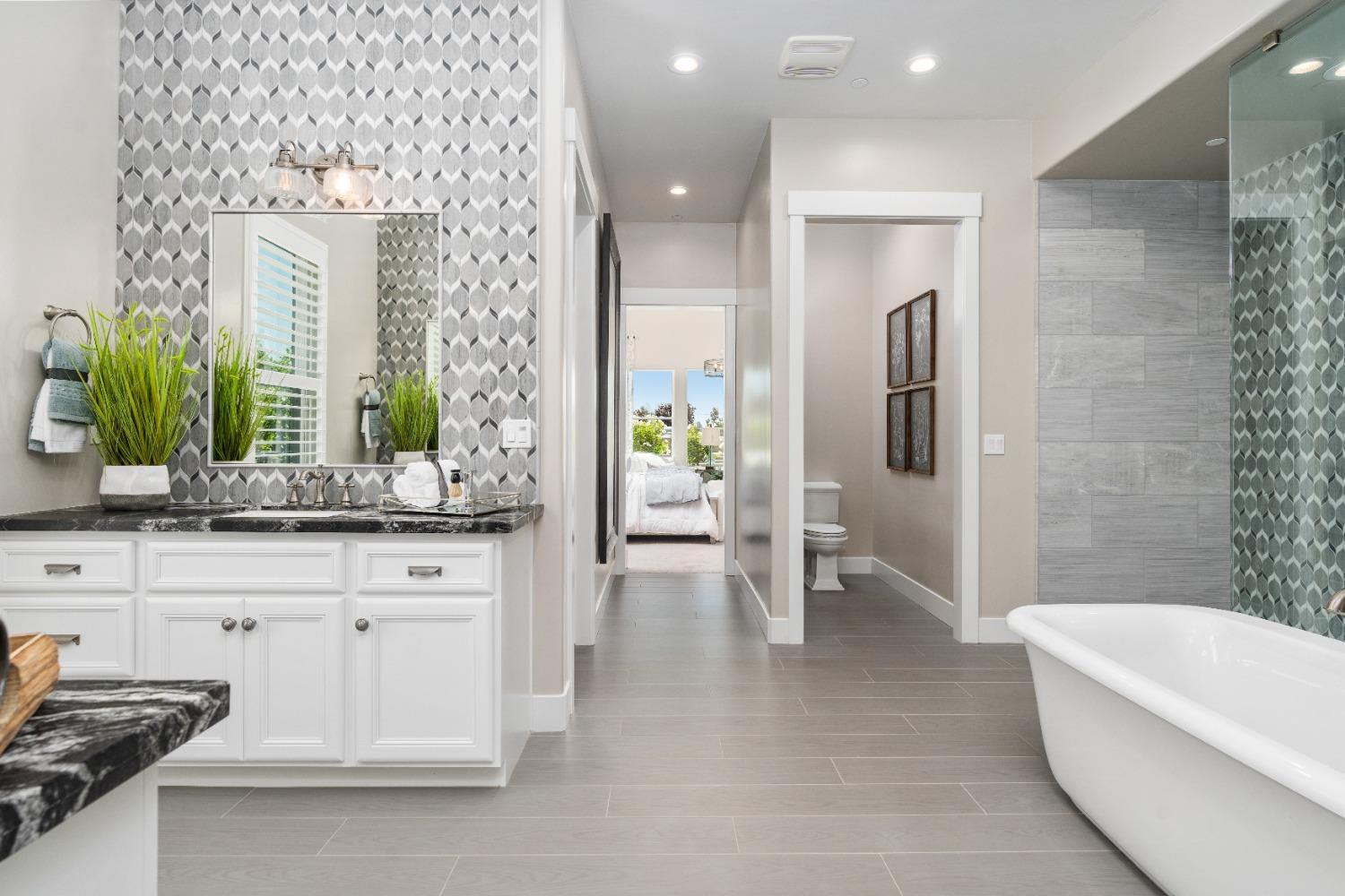 1754 Lester Avenue Clovis, CA 93619 - Photo 31 of 59 a spacious bathroom with a granite countertop sink a toilet a mirror and shower