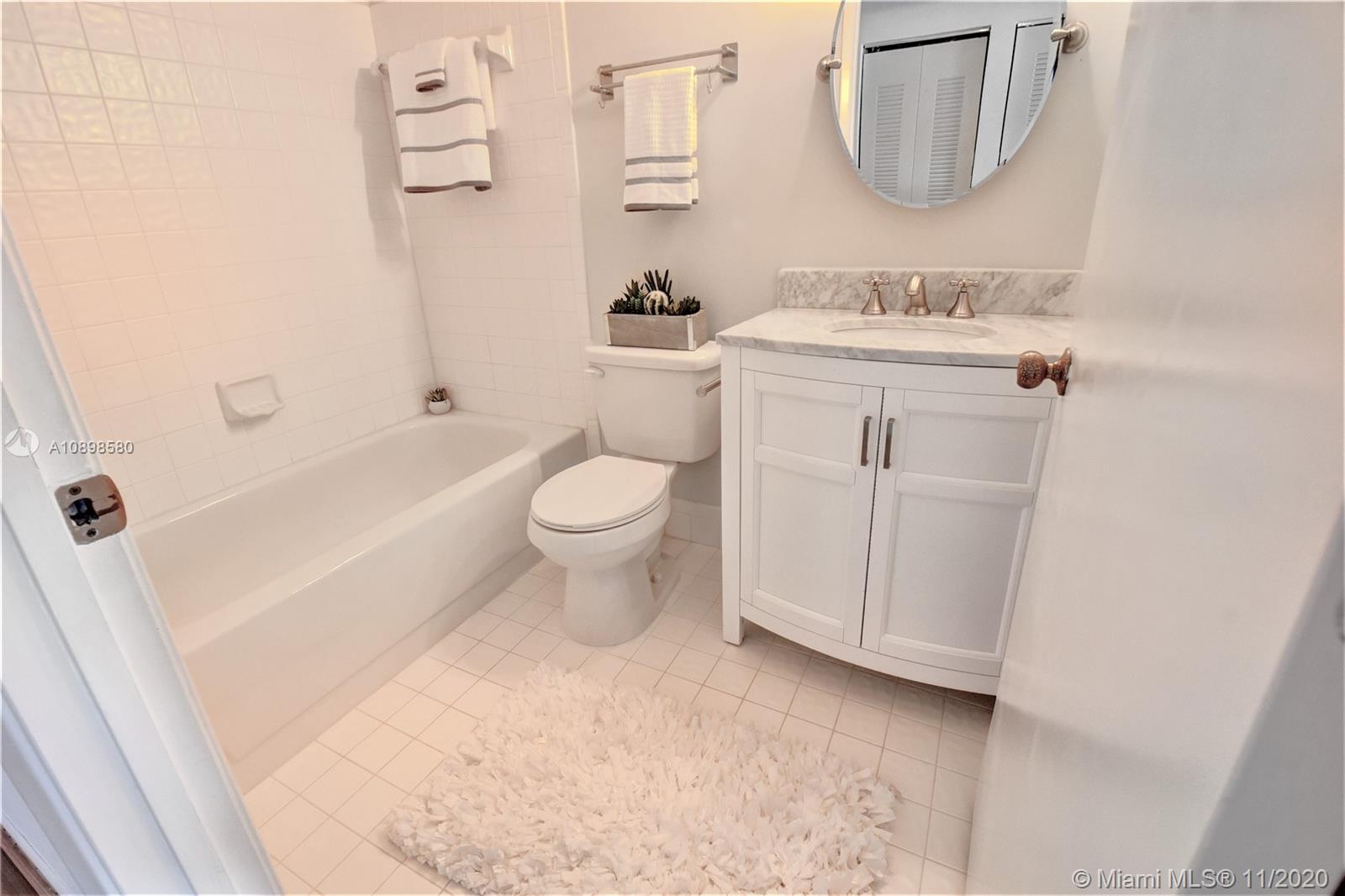 8617 Sunbird Place, Unit B Boca Raton, FL 33496 - Photo 12 of 41 a bathroom with a toilet a sink a mirror a bathtub and vanity