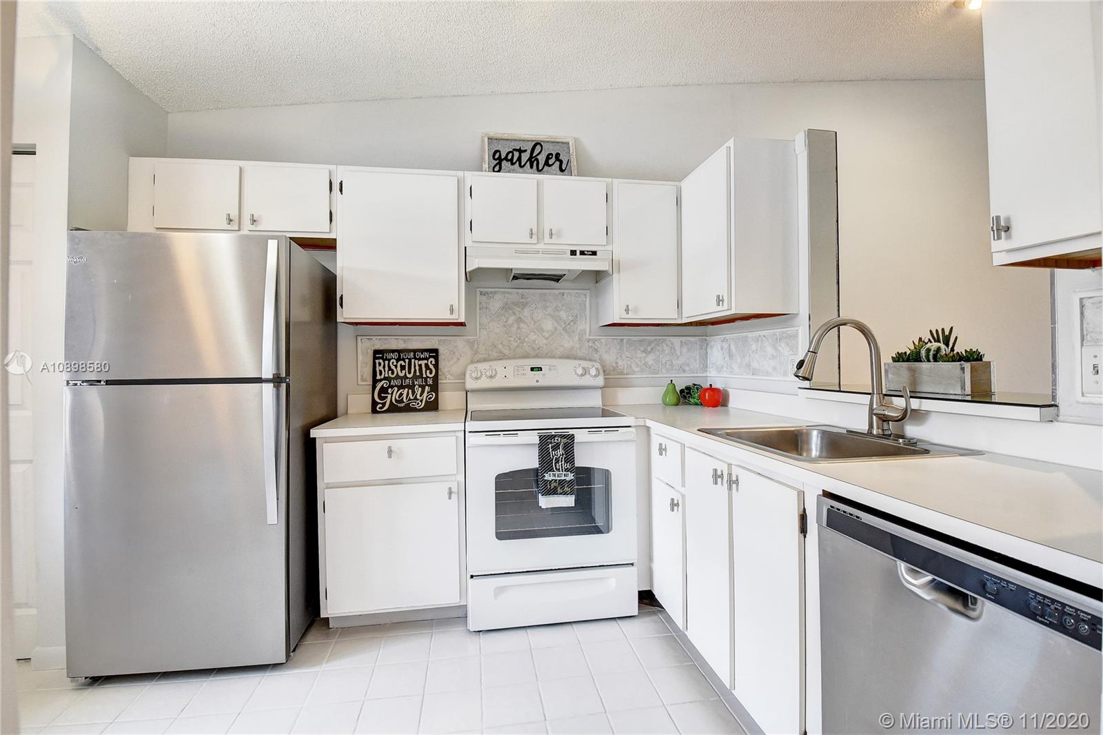 8617 Sunbird Place, Unit B Boca Raton, FL 33496 - Photo 3 of 41 a kitchen with a refrigerator sink and cabinets