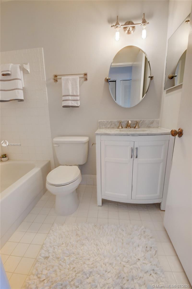 8617 Sunbird Place, Unit B Boca Raton, FL 33496 - Photo 40 of 41 a bathroom with a toilet a sink a mirror and vanity