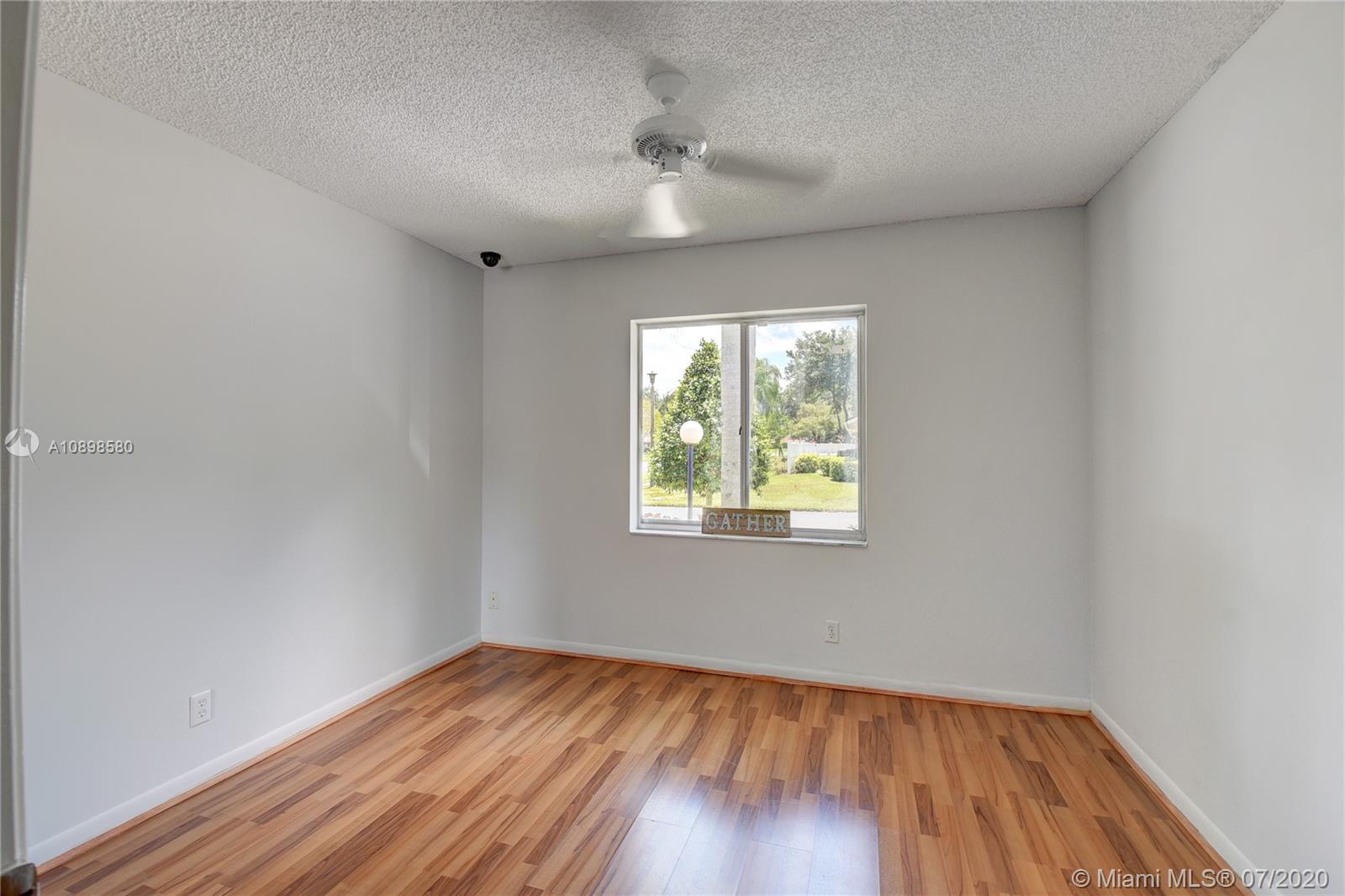8617 Sunbird Place, Unit B Boca Raton, FL 33496 - Photo 41 of 41 an empty room with wooden floor and windows
