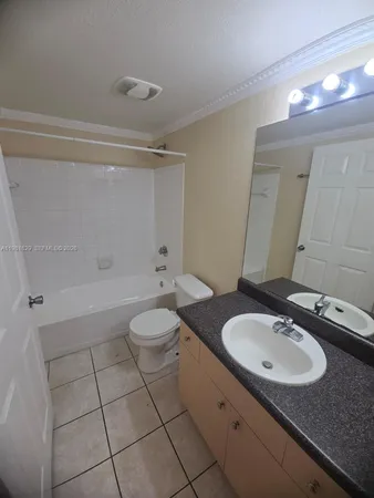 a bathroom with a granite countertop sink toilet a mirror and shower