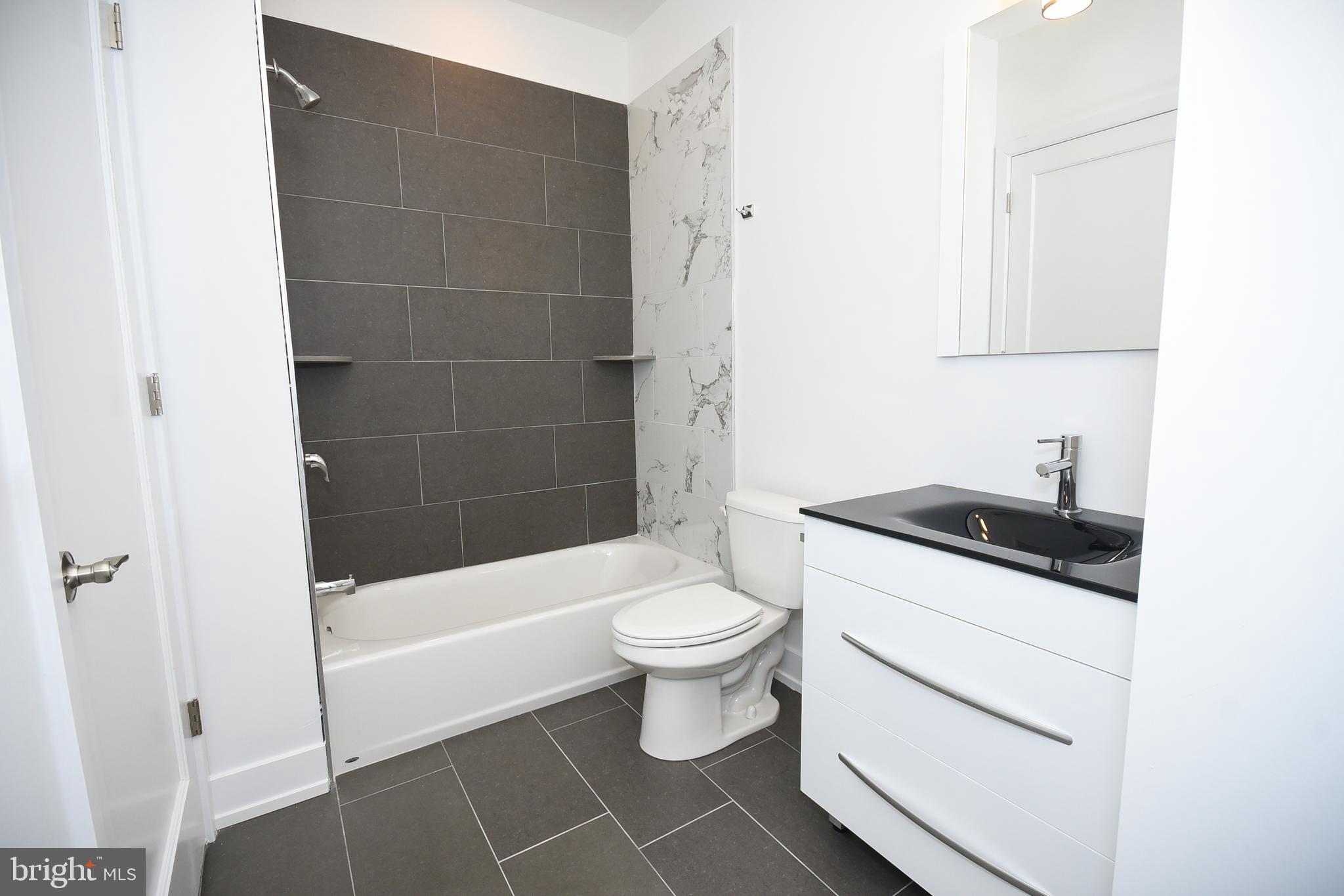 6164-66 Ridge Avenue, Unit 301 Philadelphia, PA 19128 - Photo 5 of 8 a bathroom with a sink a toilet and shower