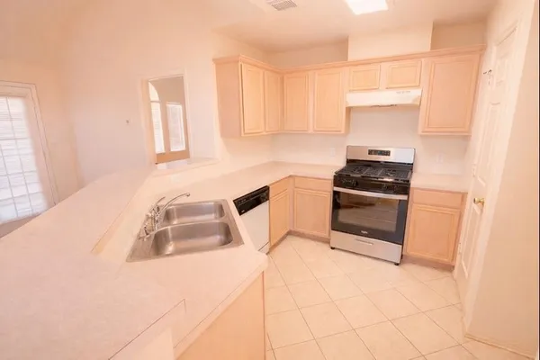 a kitchen with a sink a stove and cabinets