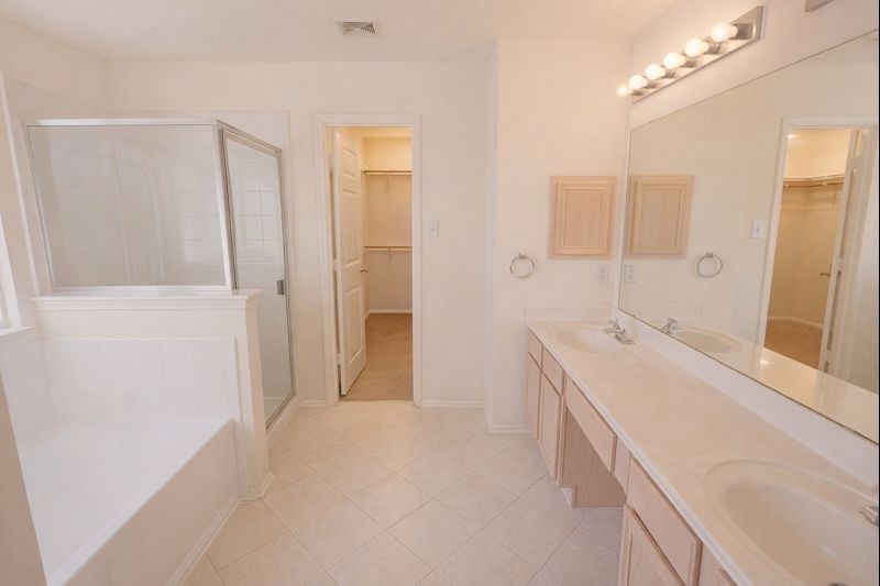 13131 Leader Trail Houston, TX 77072 - Photo 7 of 17 a bathroom with a double vanity sink a mirror and a shower