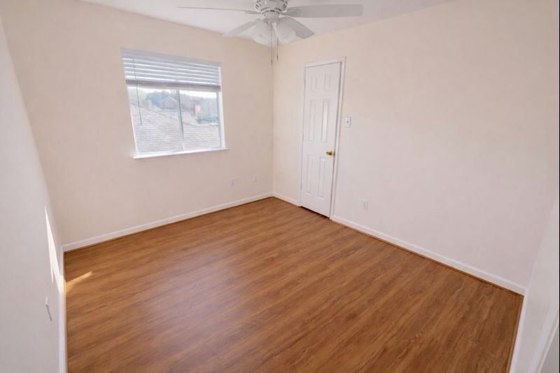 13131 Leader Trail Houston, TX 77072 - Photo 10 of 17 an empty room with a chandelier fan and windows