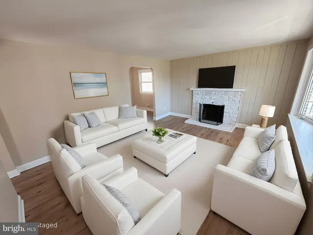 a living room with furniture a fireplace and a flat screen tv