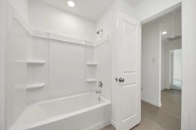 a bathroom with a bathtub and shower