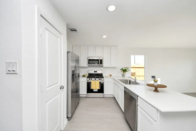 a kitchen with refrigerator and cabinets
